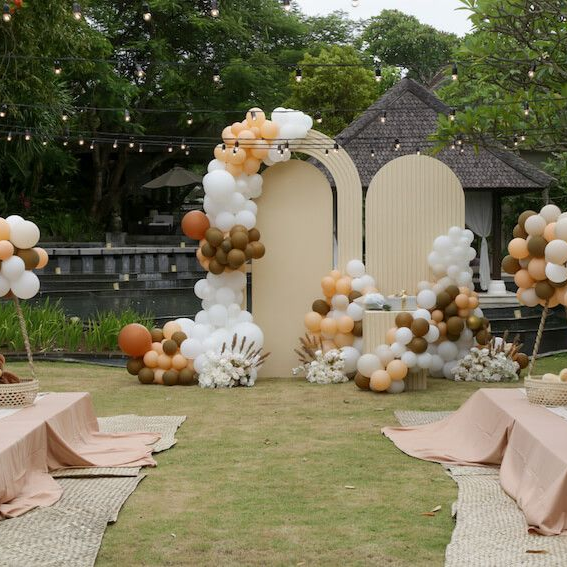 A lawn decorated with balloons and tables for a wedding ceremony.