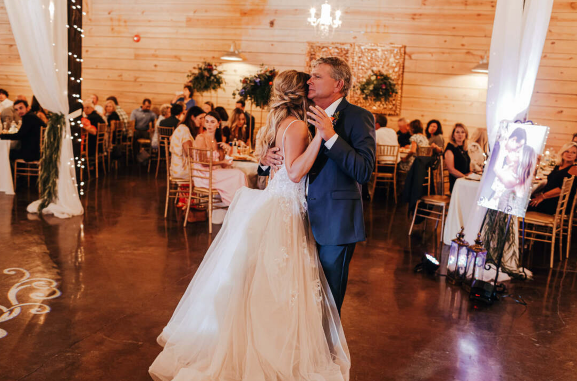 Bride and groom dancing at a wedding reception in a warmly lit hall
