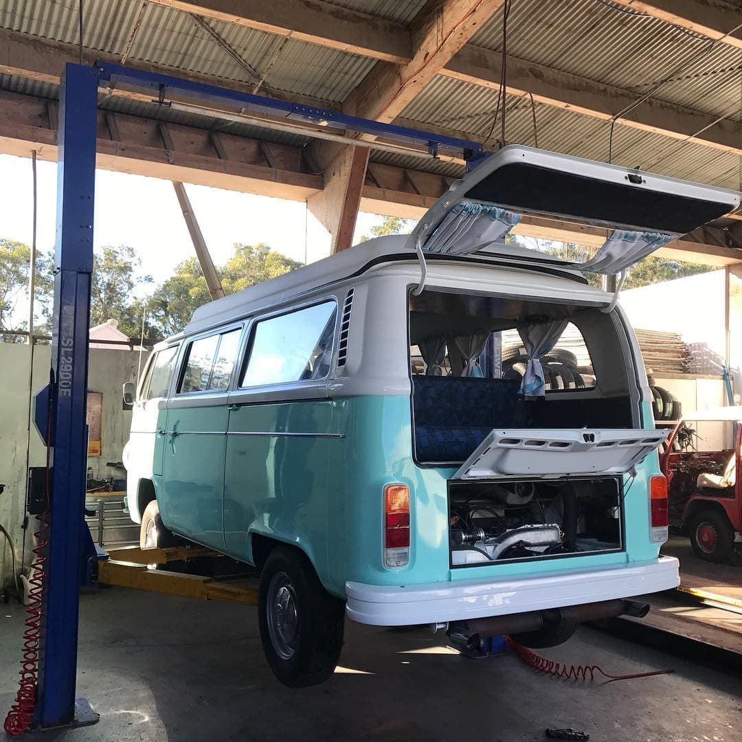 A Blue and White Van is Sitting on a Lift in a Garage — Stokers VW Mechanical Servicing & Repairs in Byron Bay, NSW