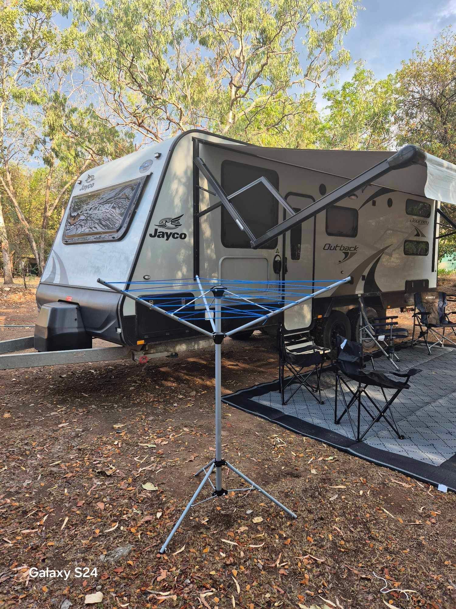 RV camper with laundry drying rack set up in a wooded campsite — Eclipse Hire In Edmonton, QLD