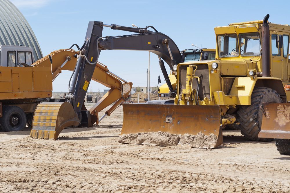 A Group Of Construction Vehicles Are Parked On A Dirt Field — Eclipse Hire In Cairns, QLD