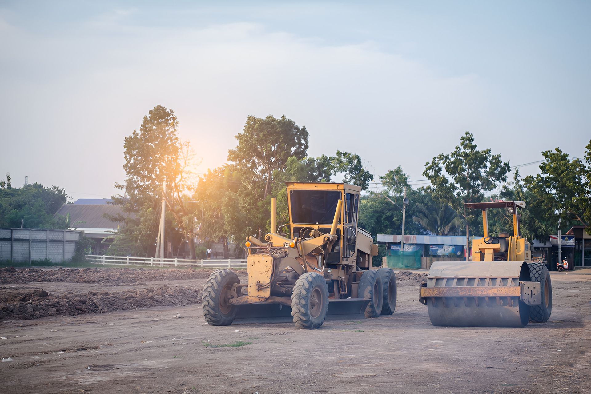 TWo Construction Vehicles Are Parked In A Dirt Field — Eclipse Hire In  Tablelands, QLD