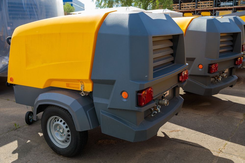 Two Air Compressors Are Parked Next To Each Other In A Parking Lot — Eclipse Hire In Edmonton, QLD