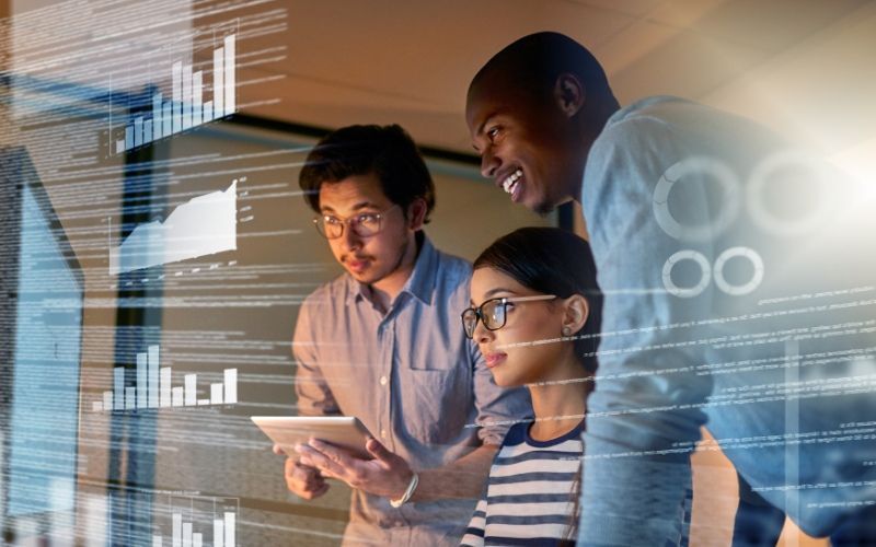A group of people are looking at a tablet using The Best Personal Finance Software for 2024