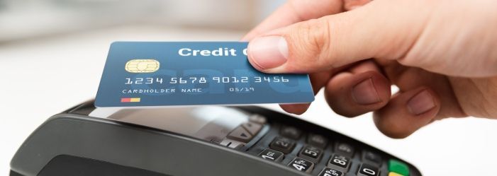 a person is using a credit card to pay for something emphasizing the idea of how to do a credit card balance transfer