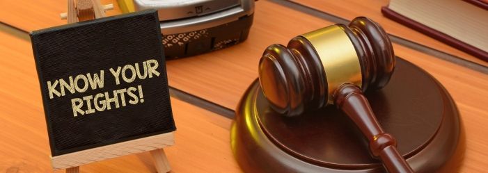 The image representation of a judge's gavel on a wooden table next to a sign that says know your rights about Debt Legal Aspect.