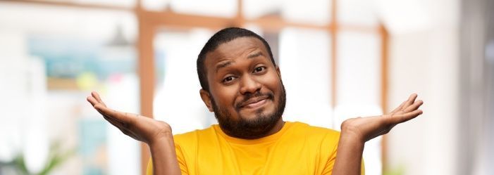 A man in a yellow shirt is shrugging his shoulders wondering What is Debt Resolution Exactly?