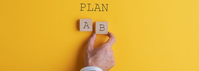 a person is holding wooden blocks with the letters A and B on them wondering if it is good to Pay Off Debt or Save Money.