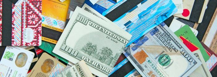 A pile of money and credit cards on a table.