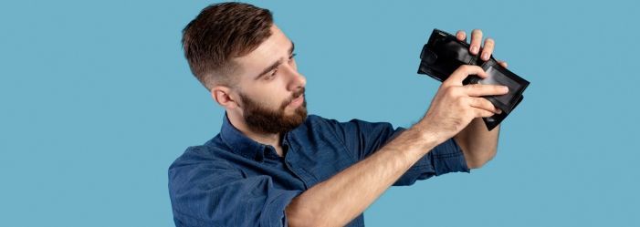 Man calmly holding an open, empty wallet, reassured by the option of Chapter 7 bankruptcy for financial relief.