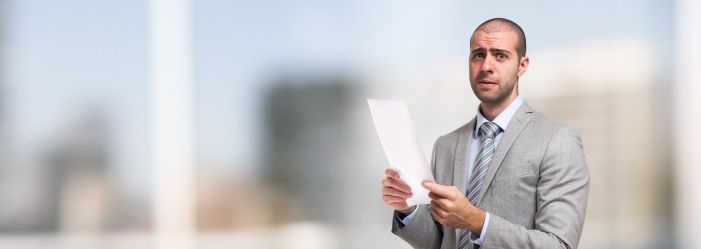 A man in a suit and tie is holding a Debt Settlement Letter.