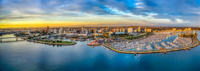 An aerial view of a city surrounded by water at sunset emphasizing Why people live in California.