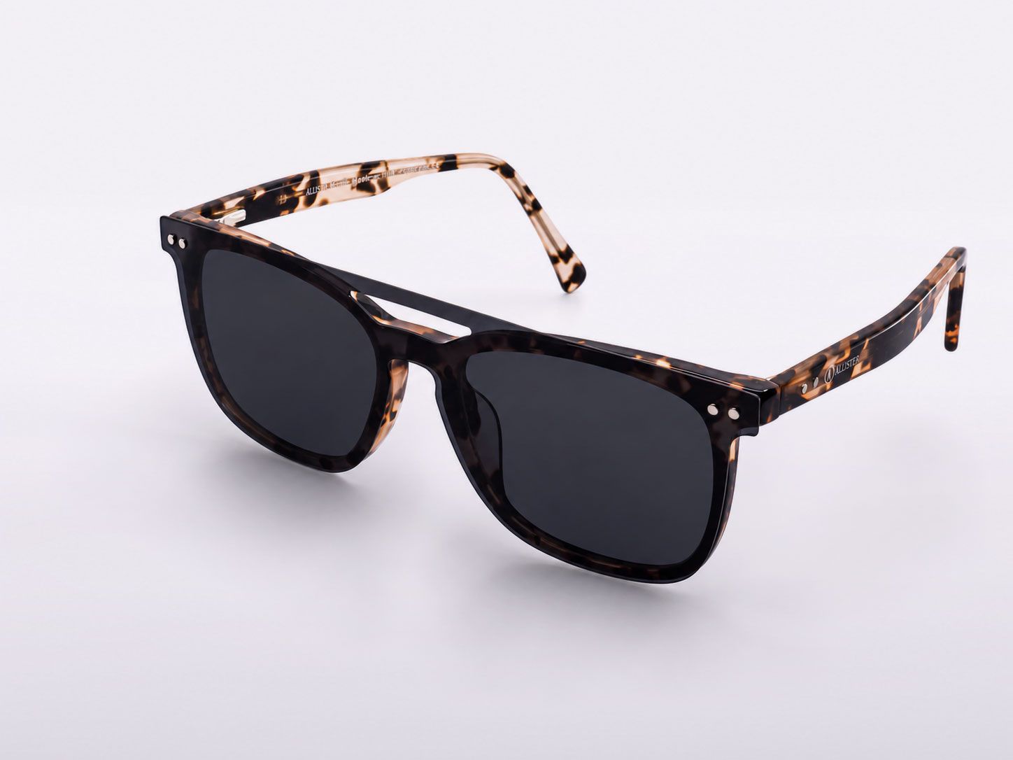 Tortoiseshell sunglasses with dark lenses on a white background