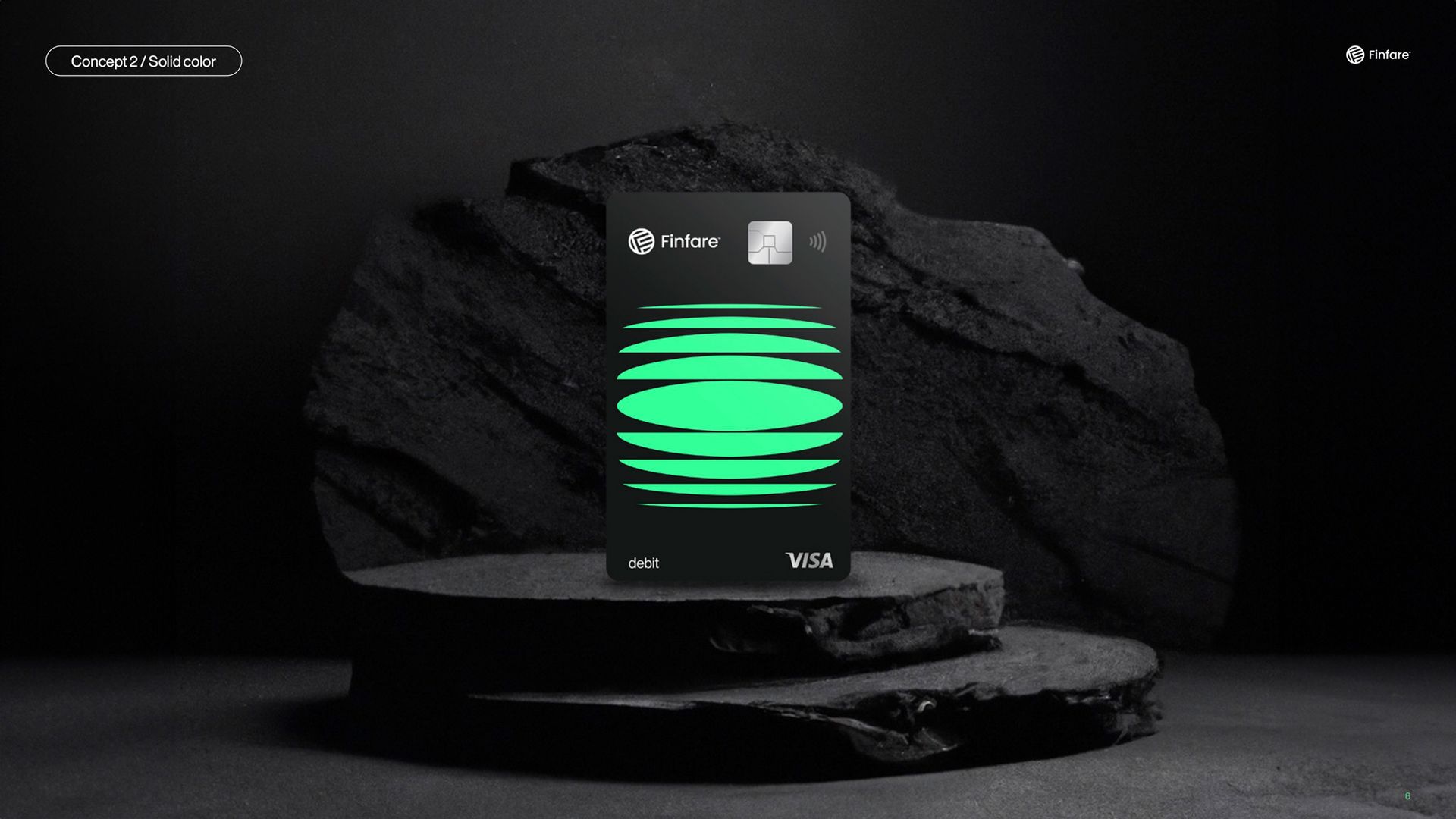 Black credit card with green design, displayed on a dark surface and against a dark background.