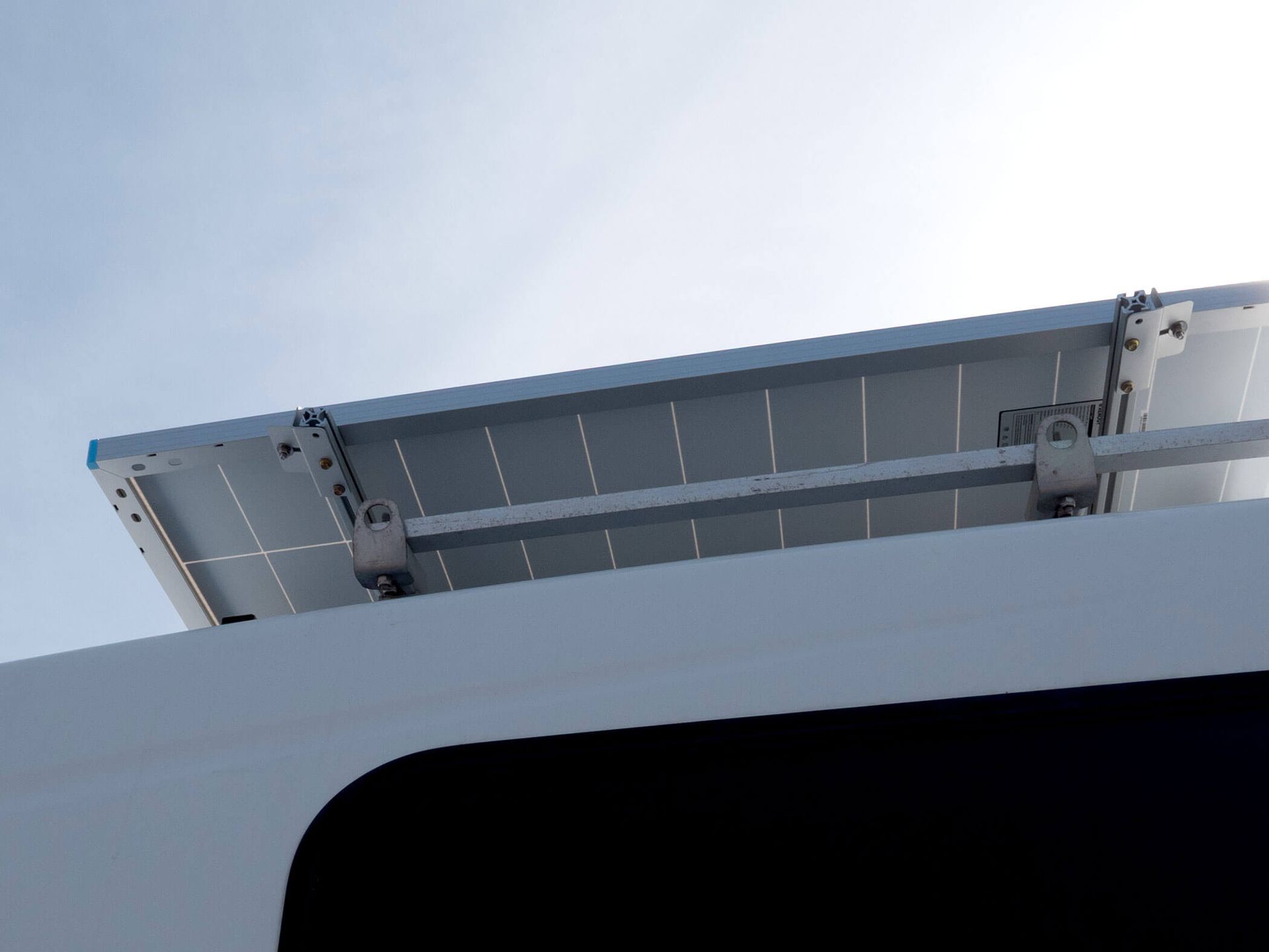 Close-up of a solar panel mounted on a vehicle roof against the sky