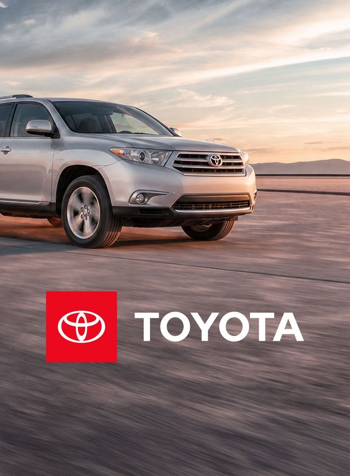 Silver Toyota SUV driving on a road at sunset, with Toyota logo displayed.