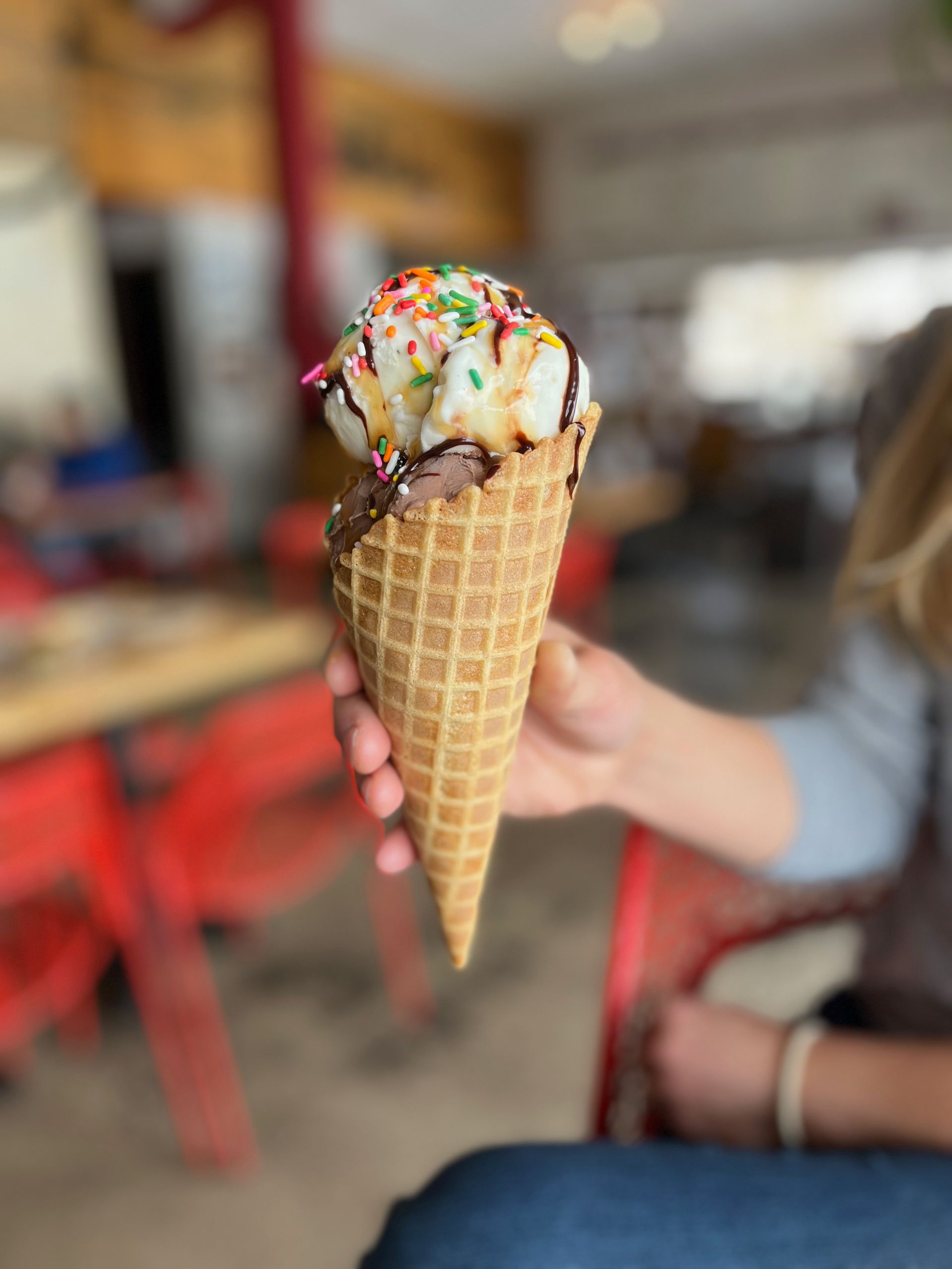 ice cream cone with sprinkles in hand
