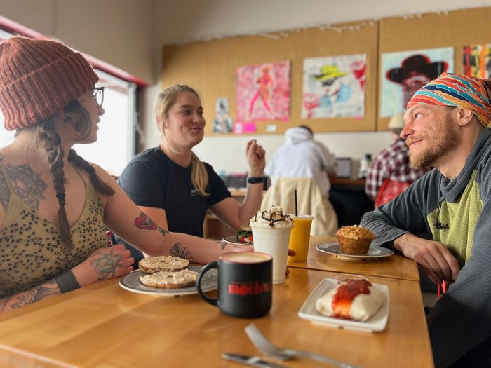 mochas barista handing customer a coffee milkshake