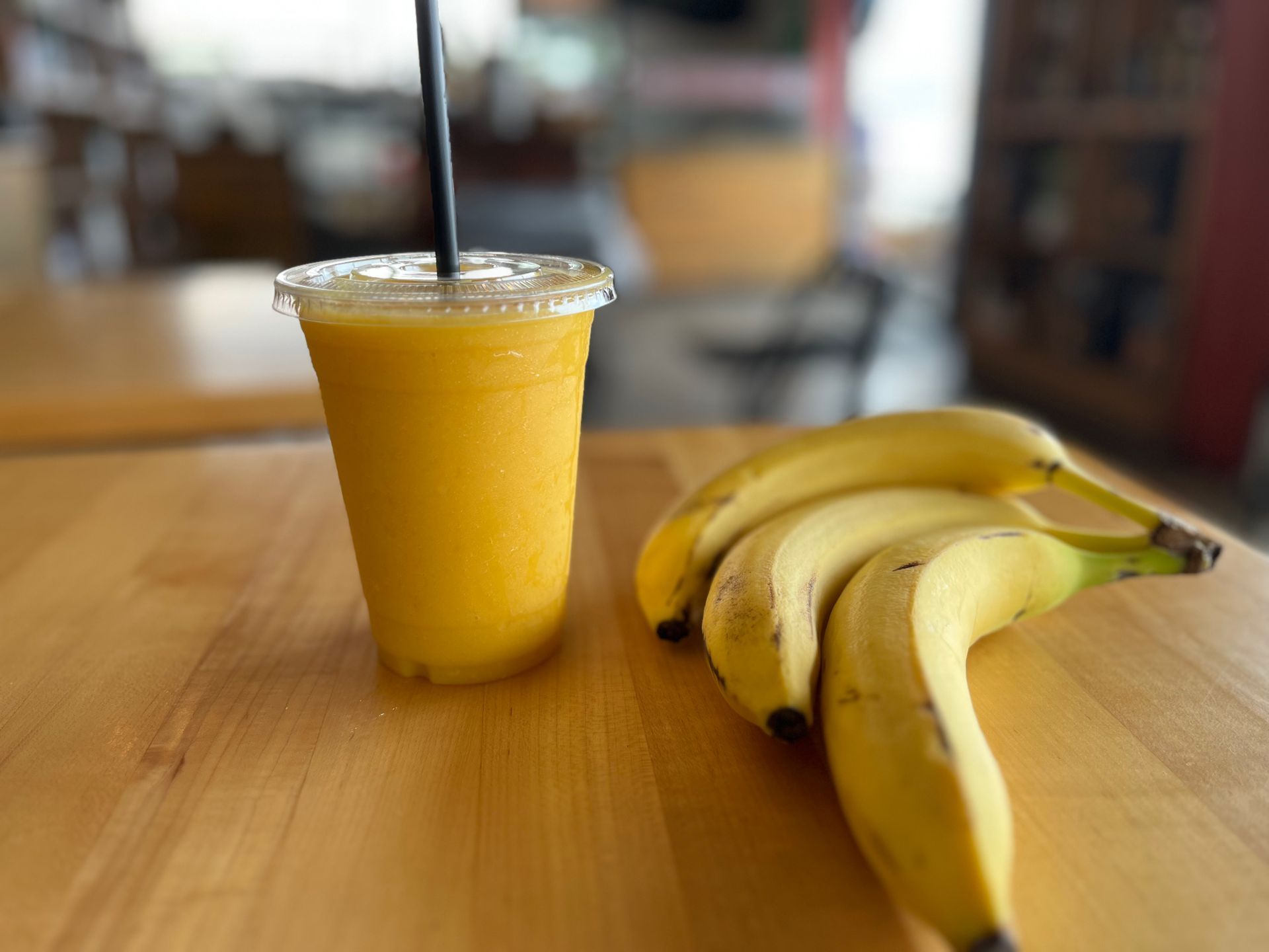 orange smoothie next to bananas