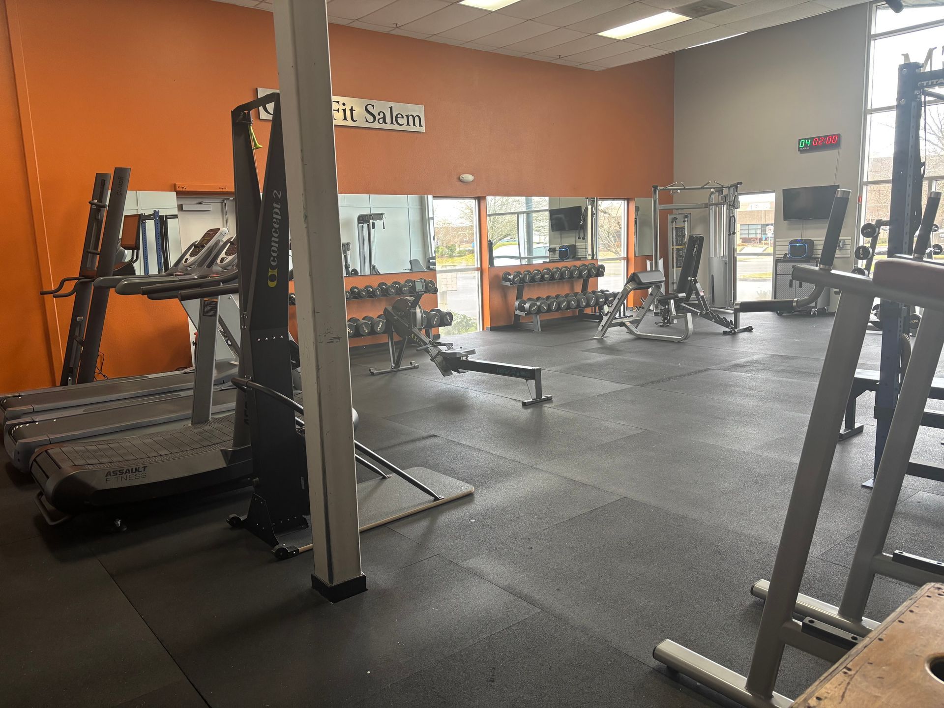 A gym filled with lots of exercise equipment and a treadmill.
