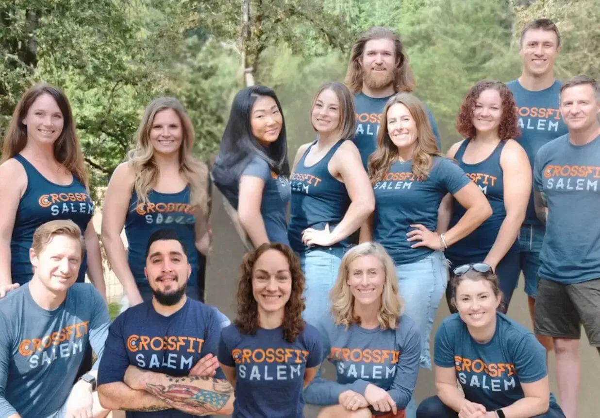 A group of people wearing crossfit shirts are posing for a picture.