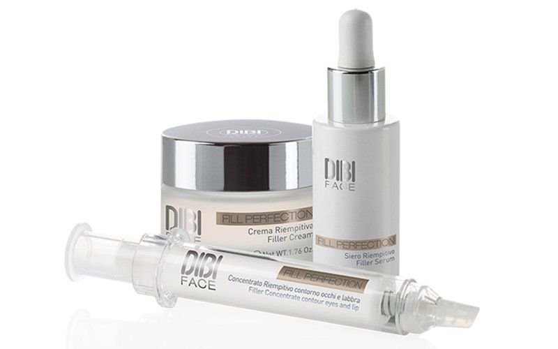 Vari prodotti per la cura della pelle di colore bianco: vasetto, flacone con contagocce e tubetto di crema a forma di siringa su sfondo bianco.