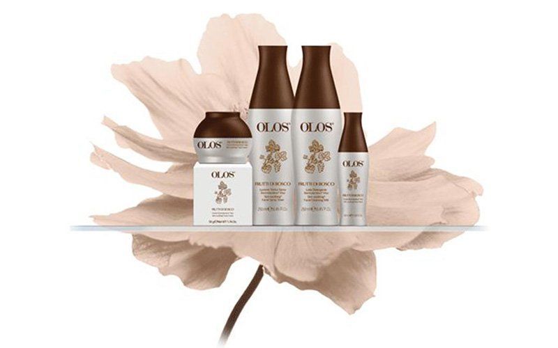 Prodotti per la cura dei capelli OLAPLEX disposti su uno scaffale con sfondo di petali di fiori beige.