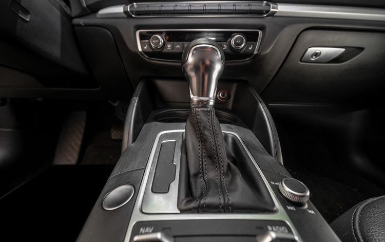Car interior with automatic gear shift and center console controls, shown in dark trim.