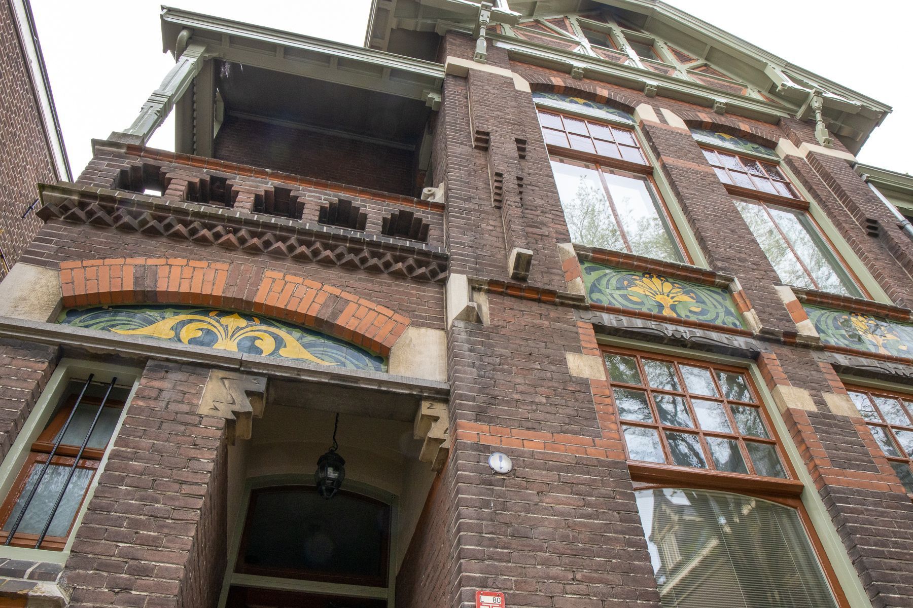 een groot bakstenen gebouw met veel ramen en een balkon.