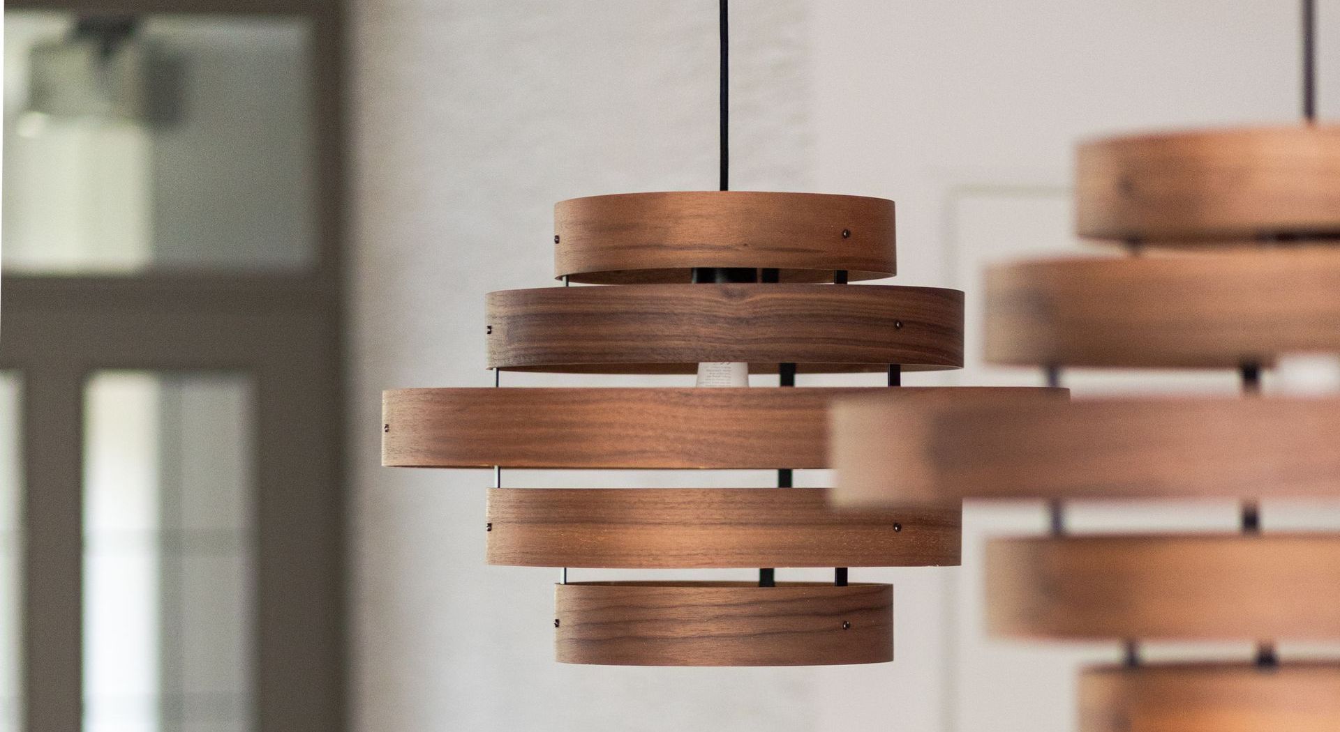 Hanglampen van gelaagd hout hangen aan het plafond.