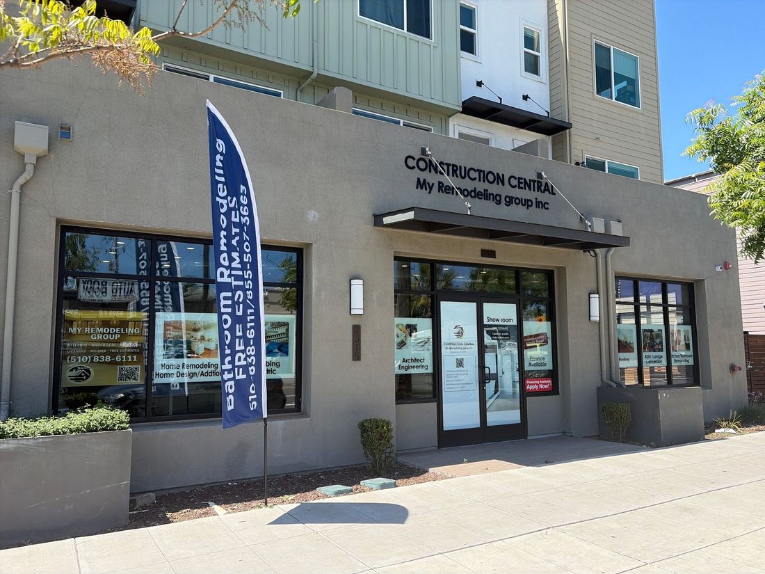 Exterior of a community center with glass doors, windows, and a blue banner on the sidewalk