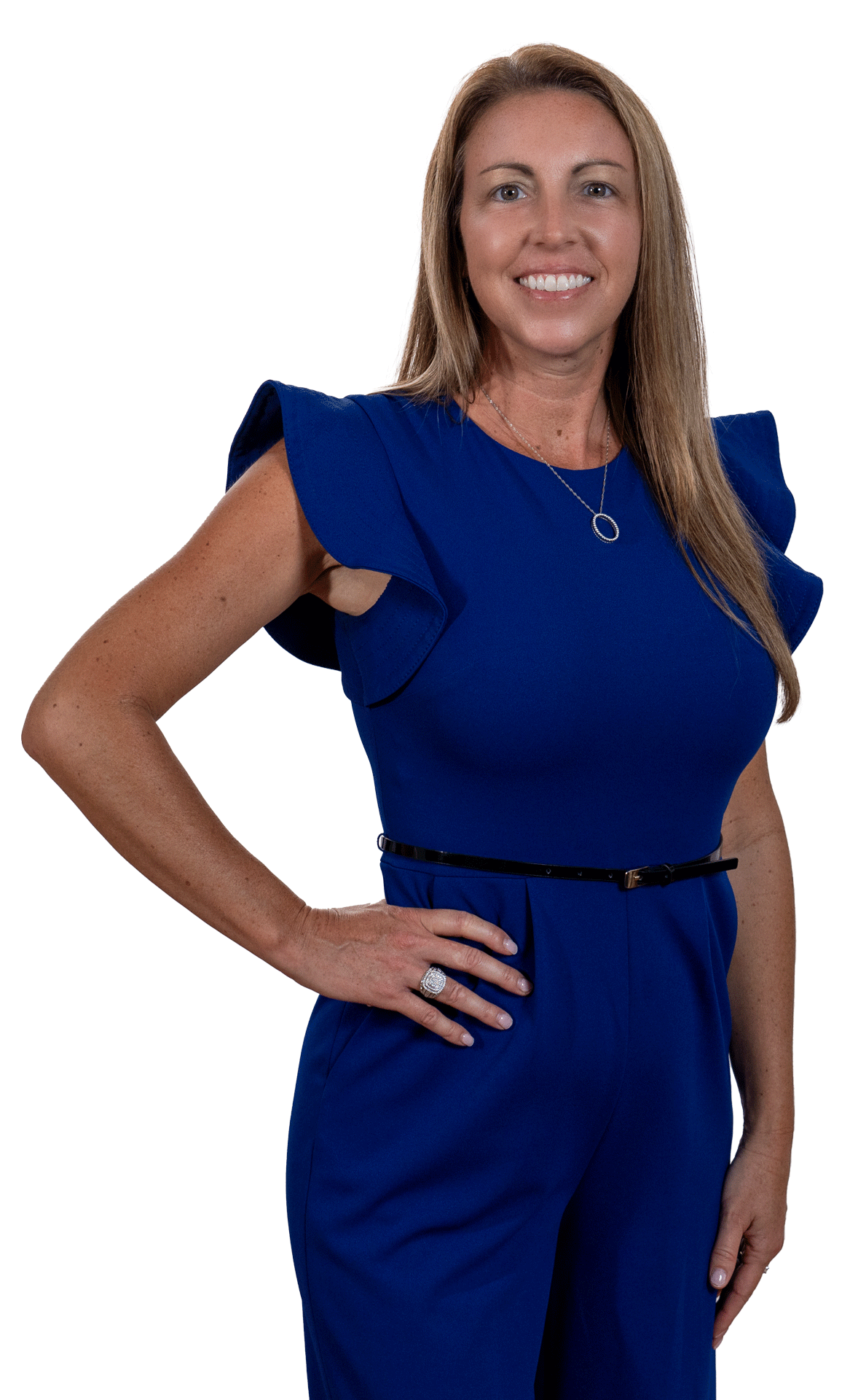 Woman in a royal blue dress standing against a white background, smiling with one hand on her hip