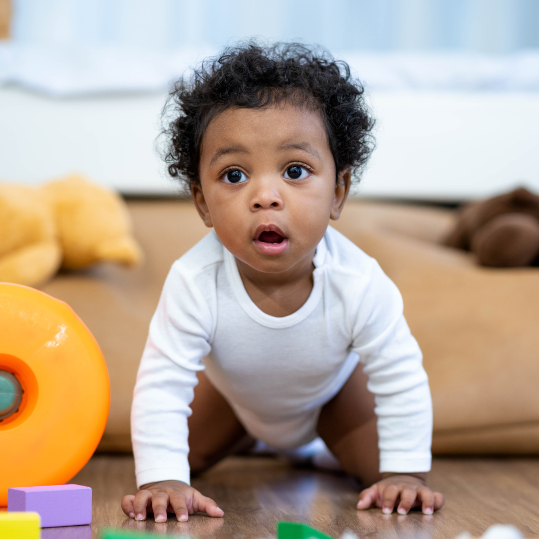 a baby is crawling on the floor surrounded by toys