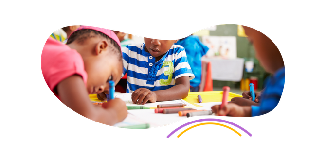 a group of children are sitting at a table drawing with crayons .