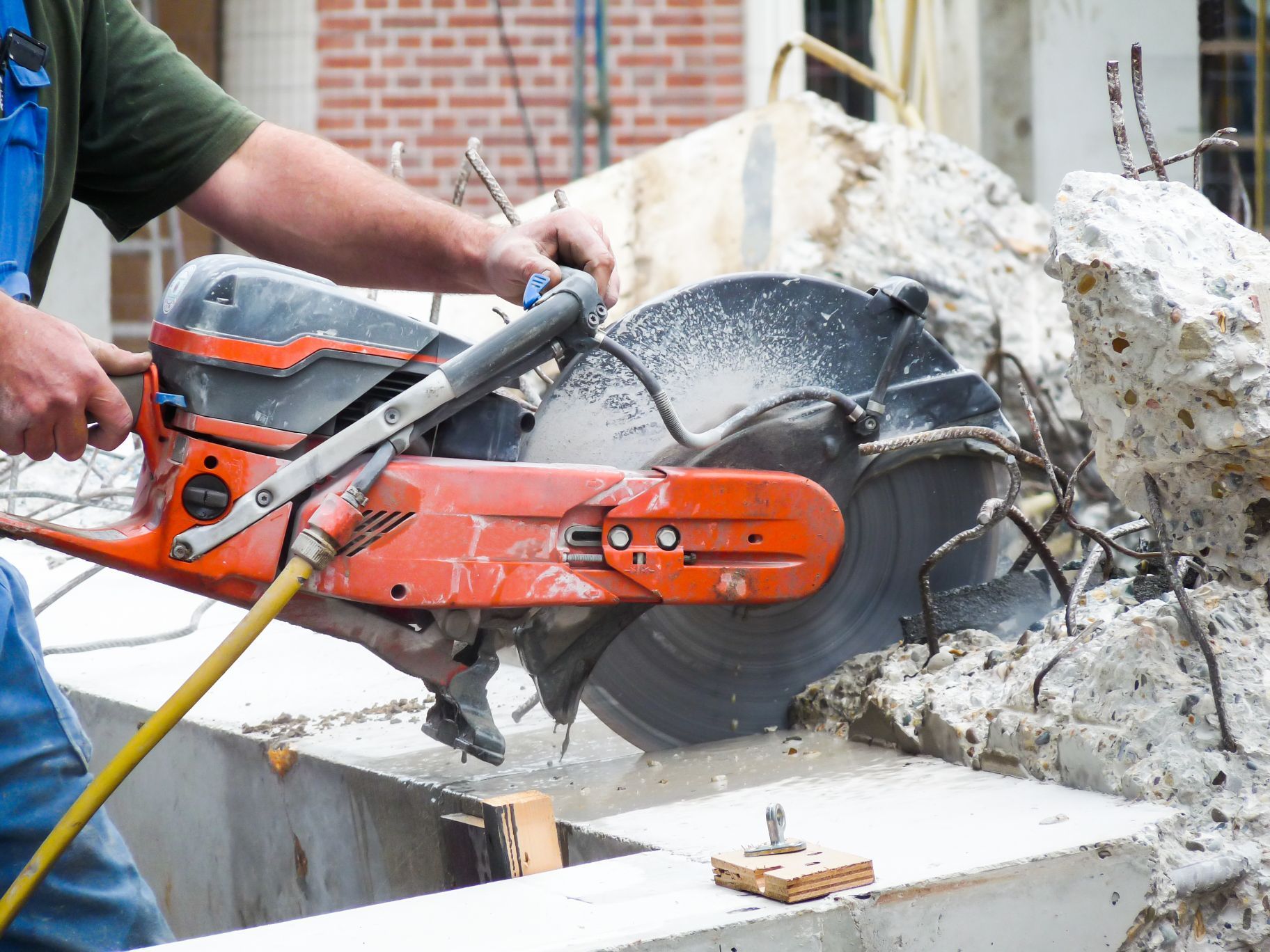 arms holding grinder cutting concrete