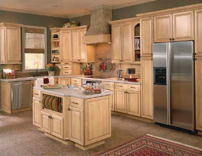 Spacious kitchen with light wood cabinets, central island, stainless steel fridge, and tiled floor.