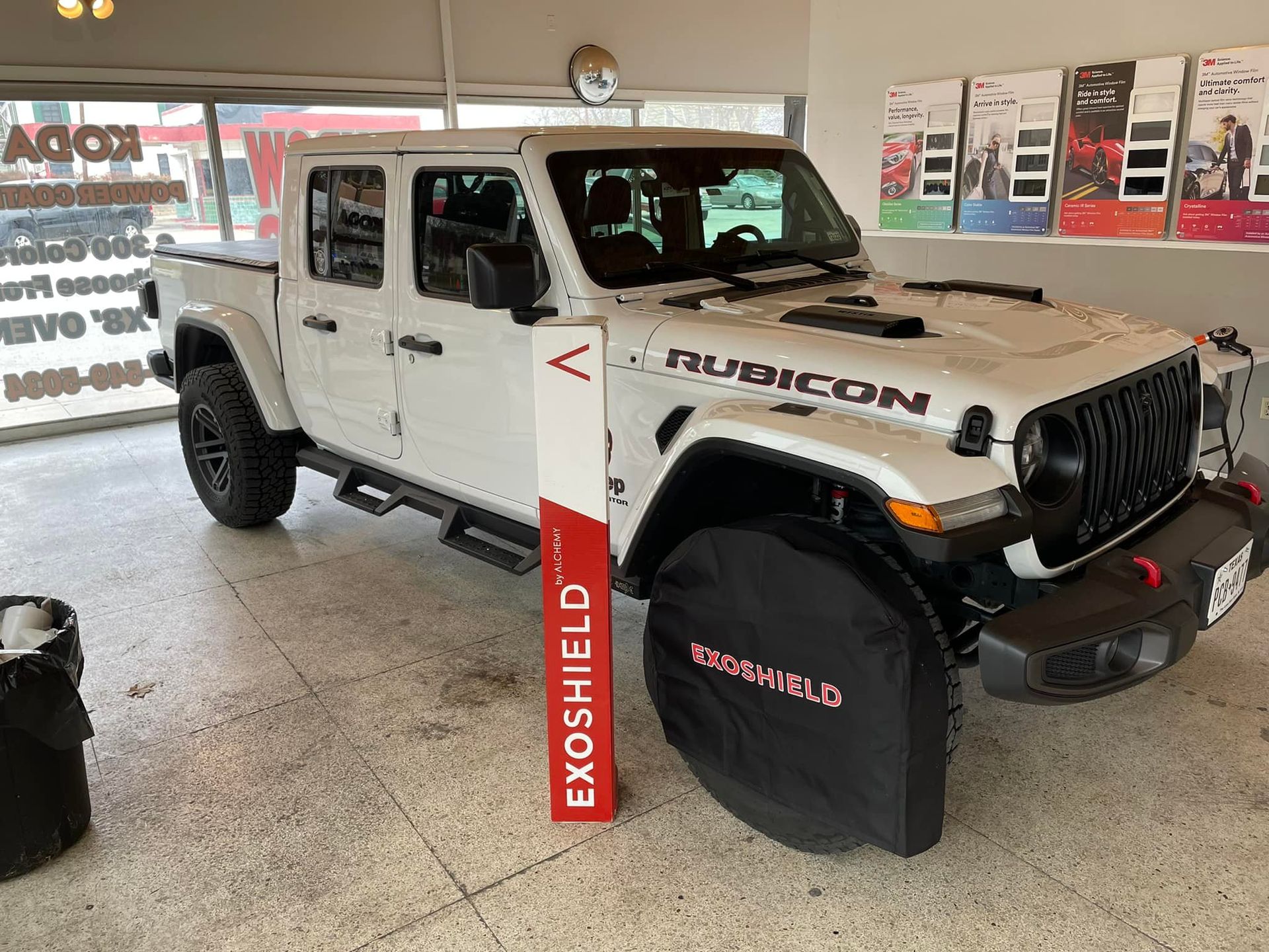 White Jeep Rubicon truck parked indoors with Exoshield display.