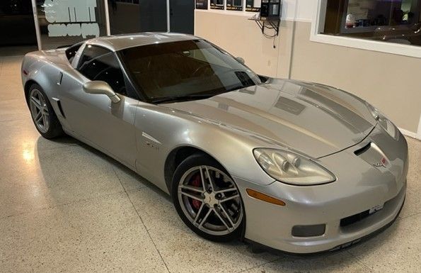 Silver Corvette sports car in a garage.