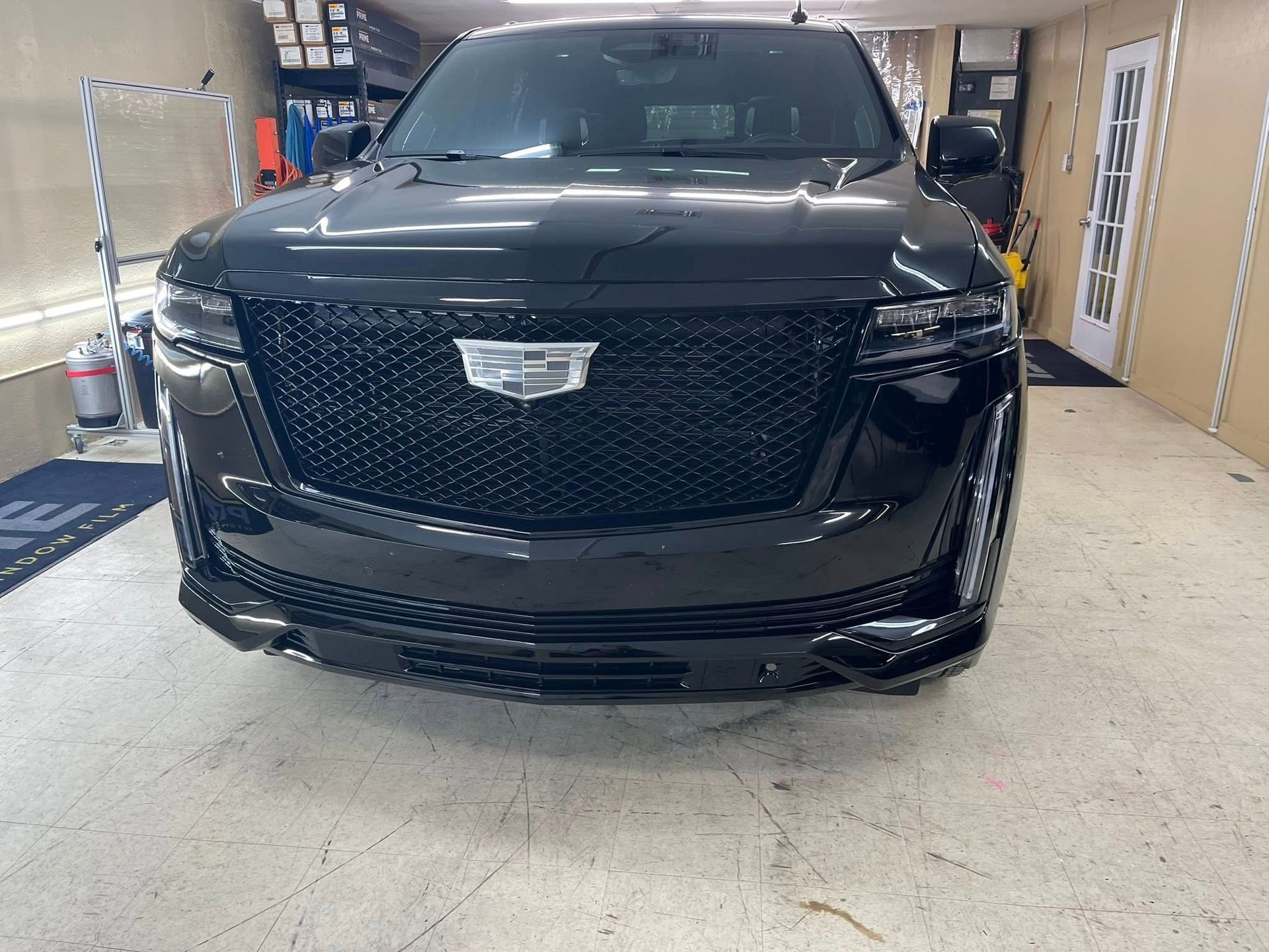 Black Cadillac Escalade parked indoors, front view.