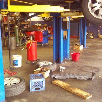 Mobile mechanic inspecting brake components beside a customer vehicle.