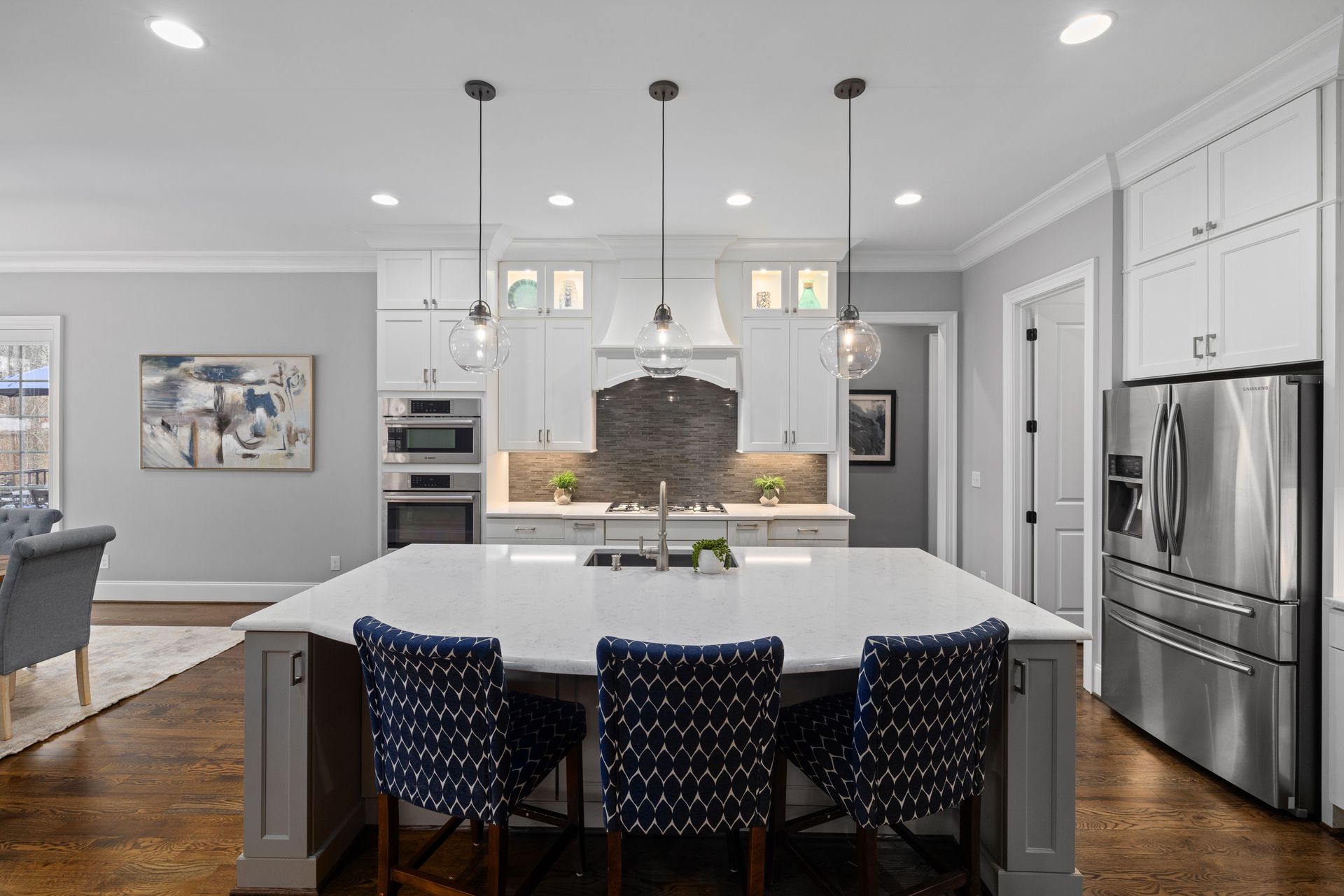 A newly renovated kitchen with large island. lighting, and dining area