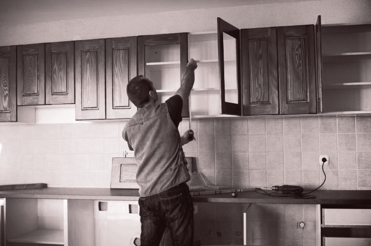 A man installing kitchen cabinets