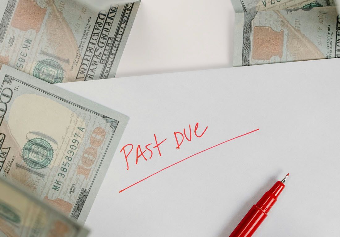A red pen rests on a white envelope marked