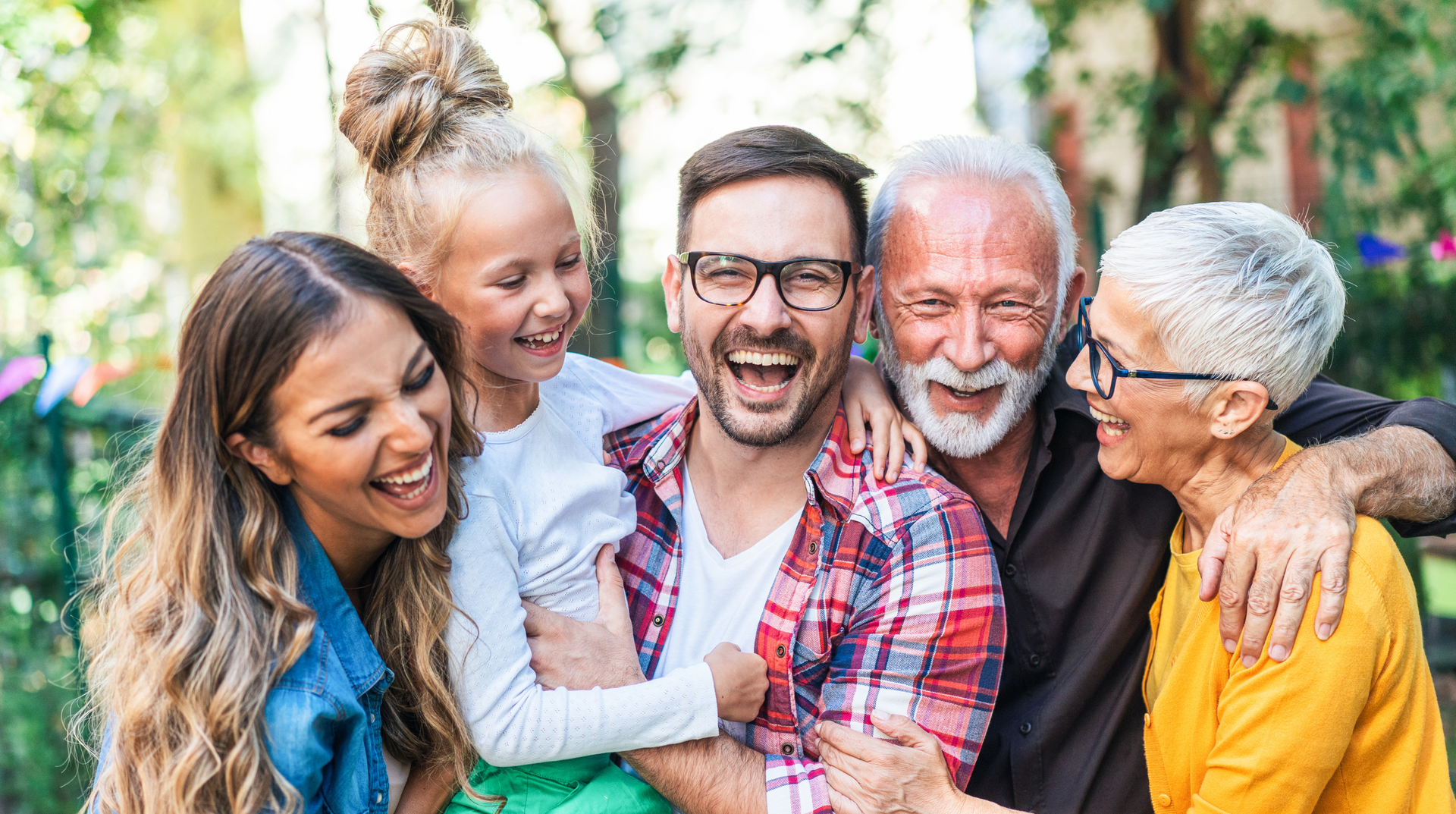 A family is posing for a picture together in a park.