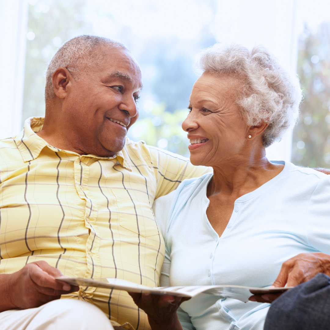 A man and woman are sitting on a couch looking at each other
