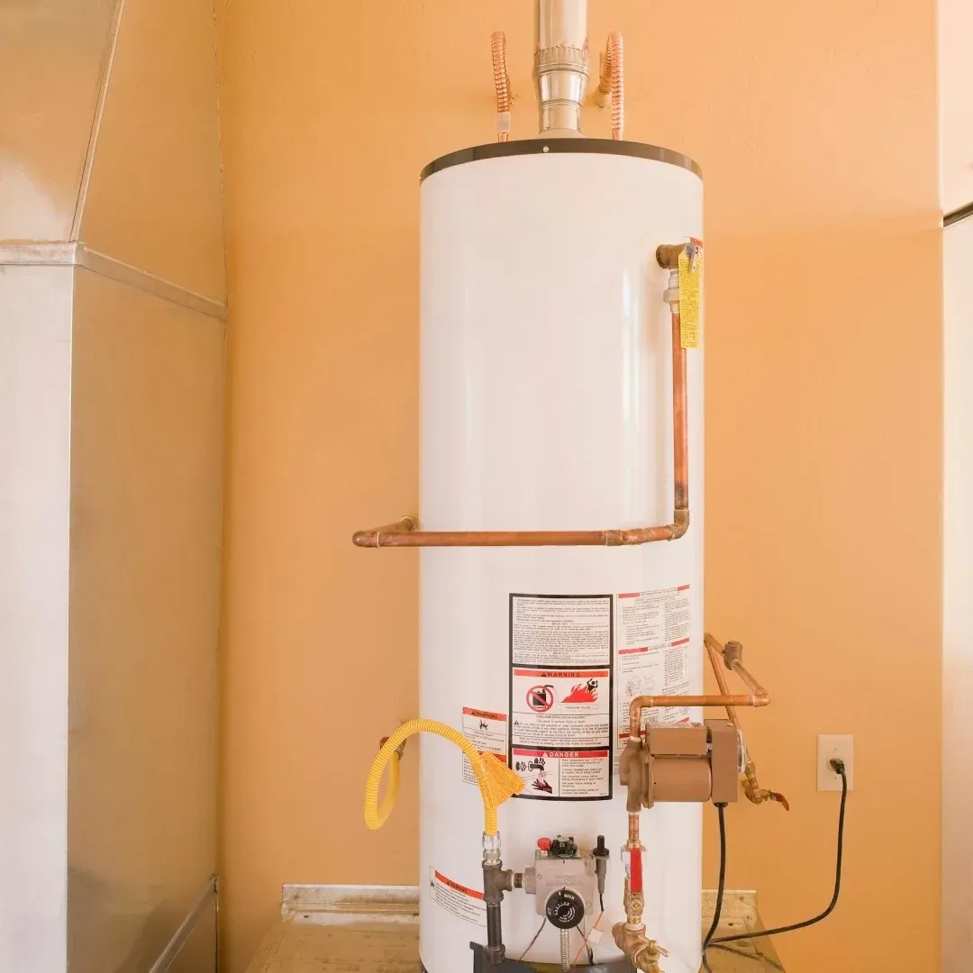White water heater with copper pipes in a utility closet