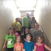 A group of children standing on a stairwell, smiling at the camera.