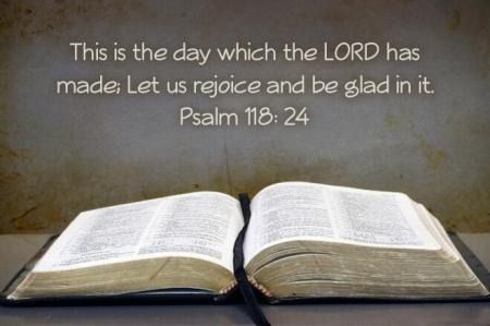 Open Bible on a table with Psalm 118:24: “This is the day which the LORD has made; let us rejoice and be glad in it.”