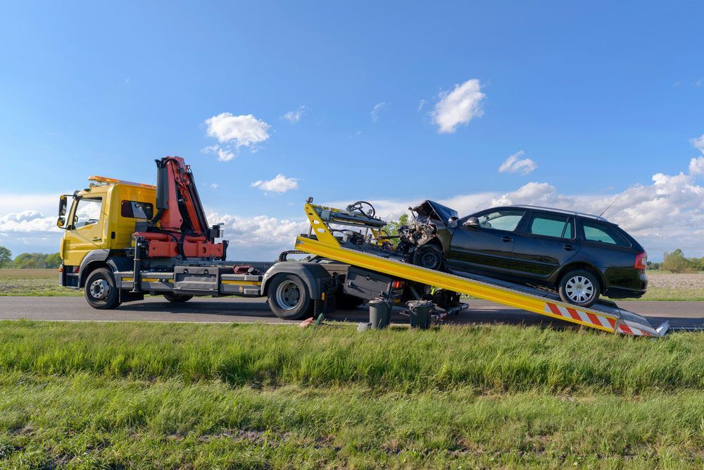 After An Accident The Crashed Car Is Pulled Onto A Tow Truck — Optimum Towing in Berry, NSW