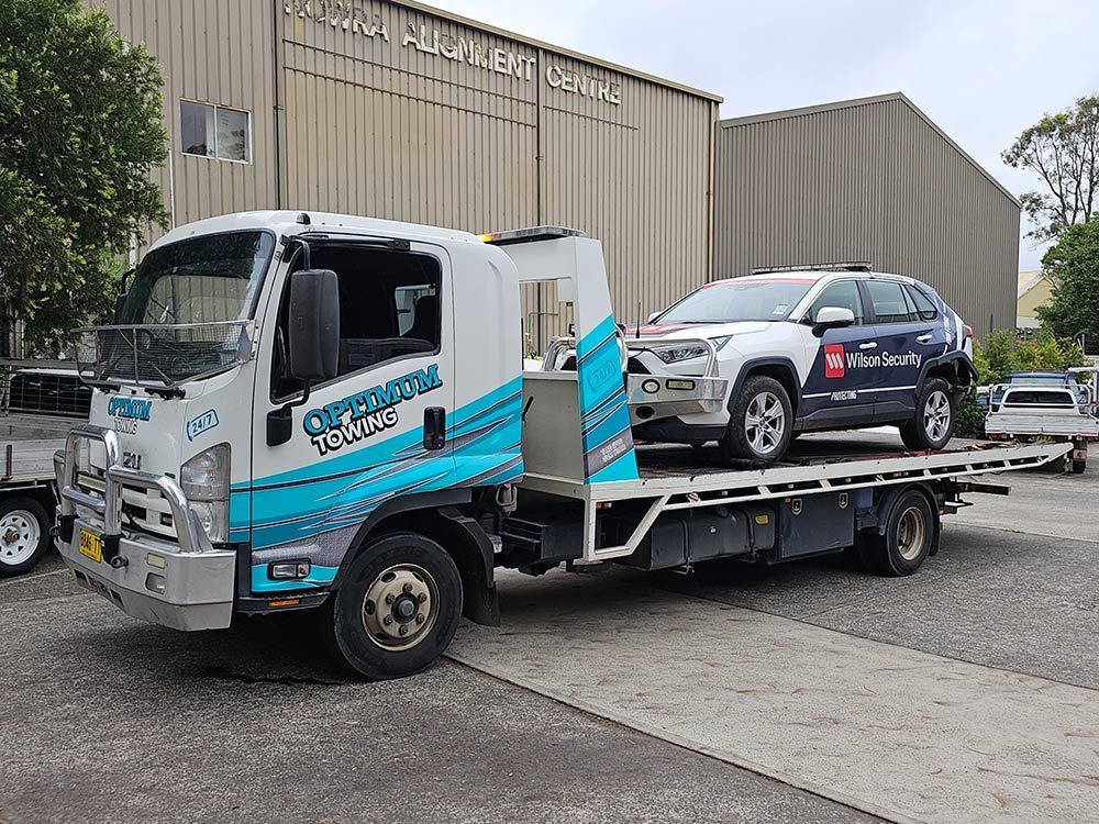 Wilson Security Car is Being Towed By Optimum Truck Towing — Optimum Towing in Bomaderry, NSW